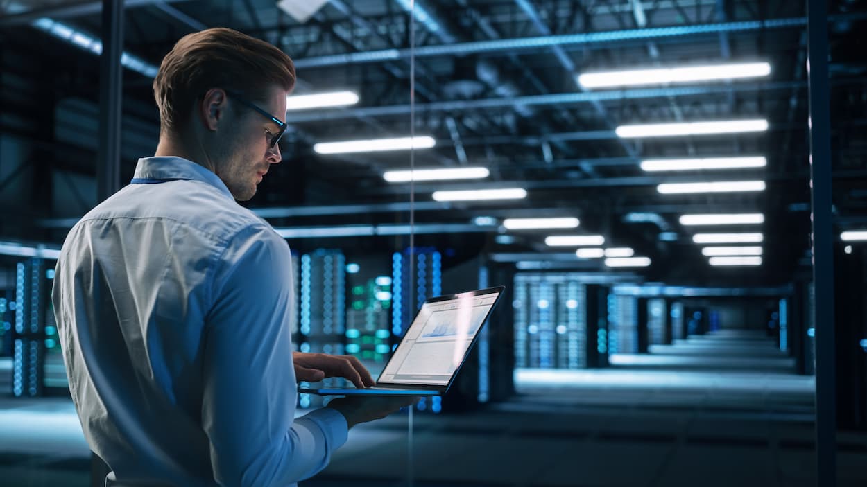 Técnico experto trabajando en un entorno de datos avanzado para supervisar y optimizar el rendimiento de las redes con Monitoreo LAN&WAN.