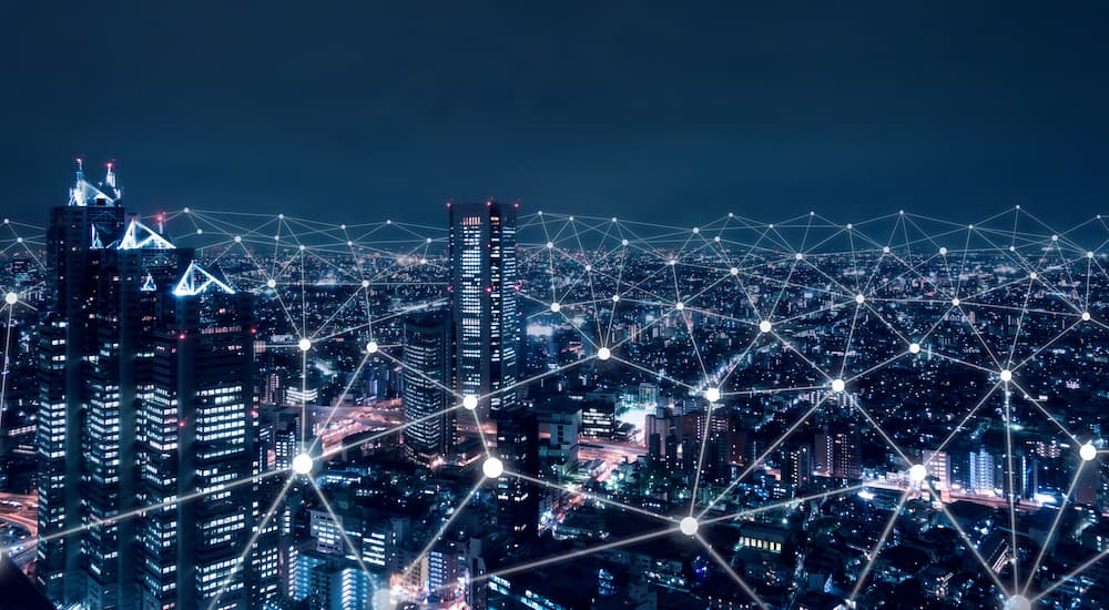 La ciudad está conectada a Internet y al mundo, simbolizando el peering y la interconexión global.