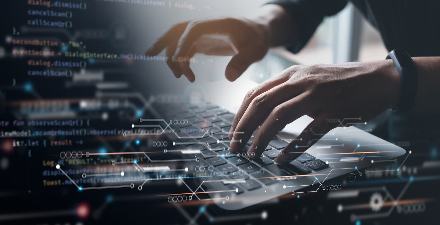 Una persona tecleando en una laptop con código visible en la pantalla, trabajando en un proyecto de internet.