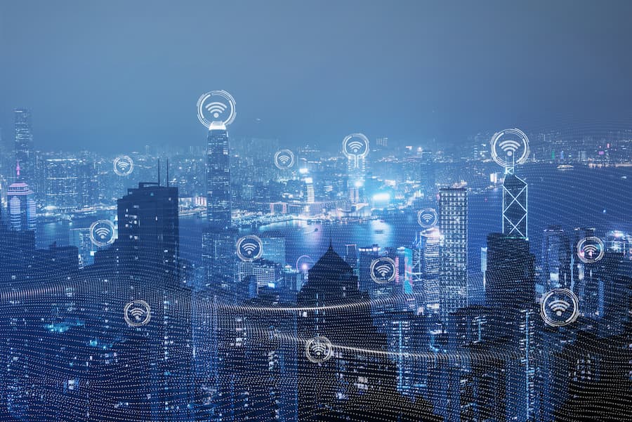 La ciudad iluminada con íconos de ciudad inteligente y Towering 5G resalta un futuro tecnológico y conectado.