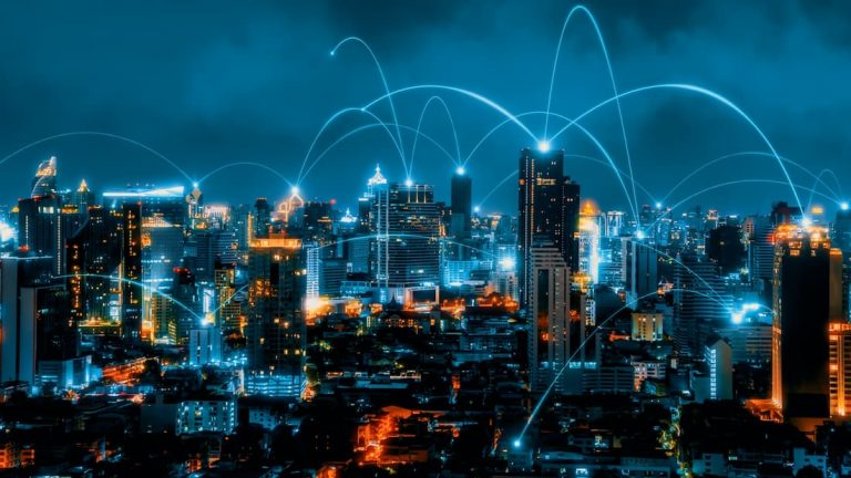 La ciudad iluminada con conexiones de red, destacando Towering 5G que se elevan sobre el paisaje urbano.