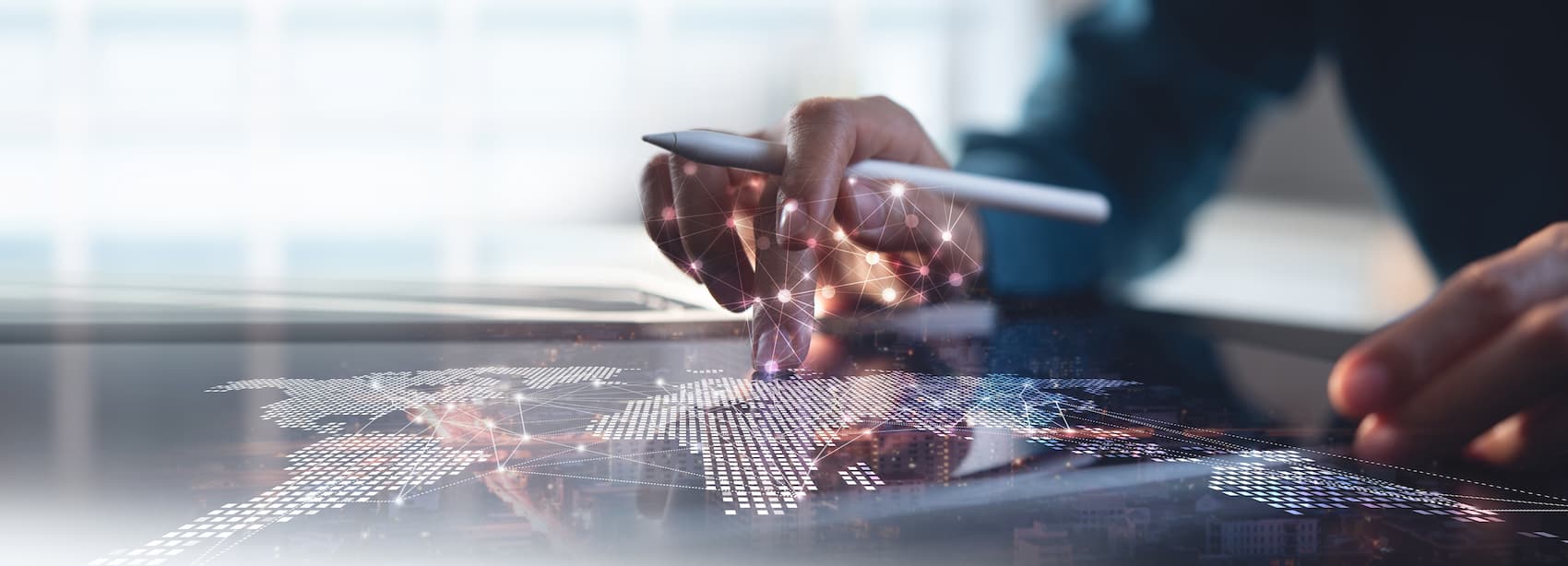 Hombre de negocios usando una tableta con un mapa digital del mundo, simbolizando la conectividad a internet.