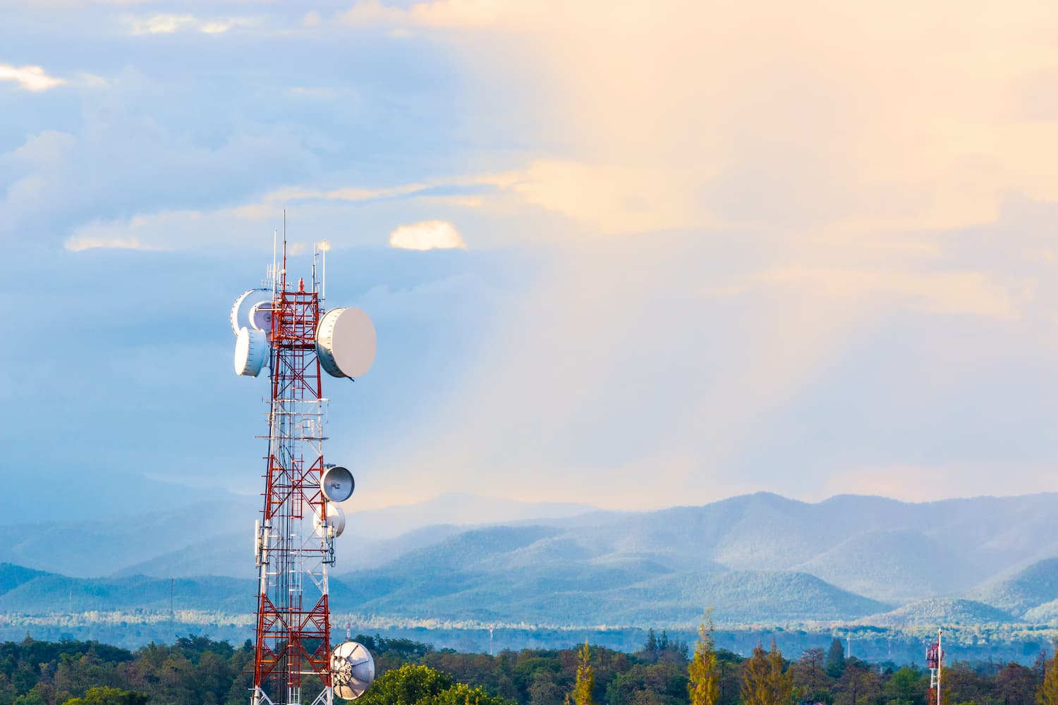 Towering 5G con una antena satelital en primer plano, destacando la infraestructura de telecomunicaciones moderna.