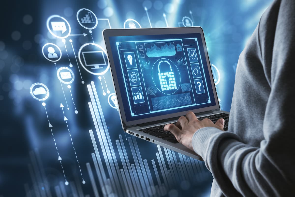 Hombre usando un portátil con un ícono de seguridad en la pantalla, simbolizando protección contra ataques DDoS.