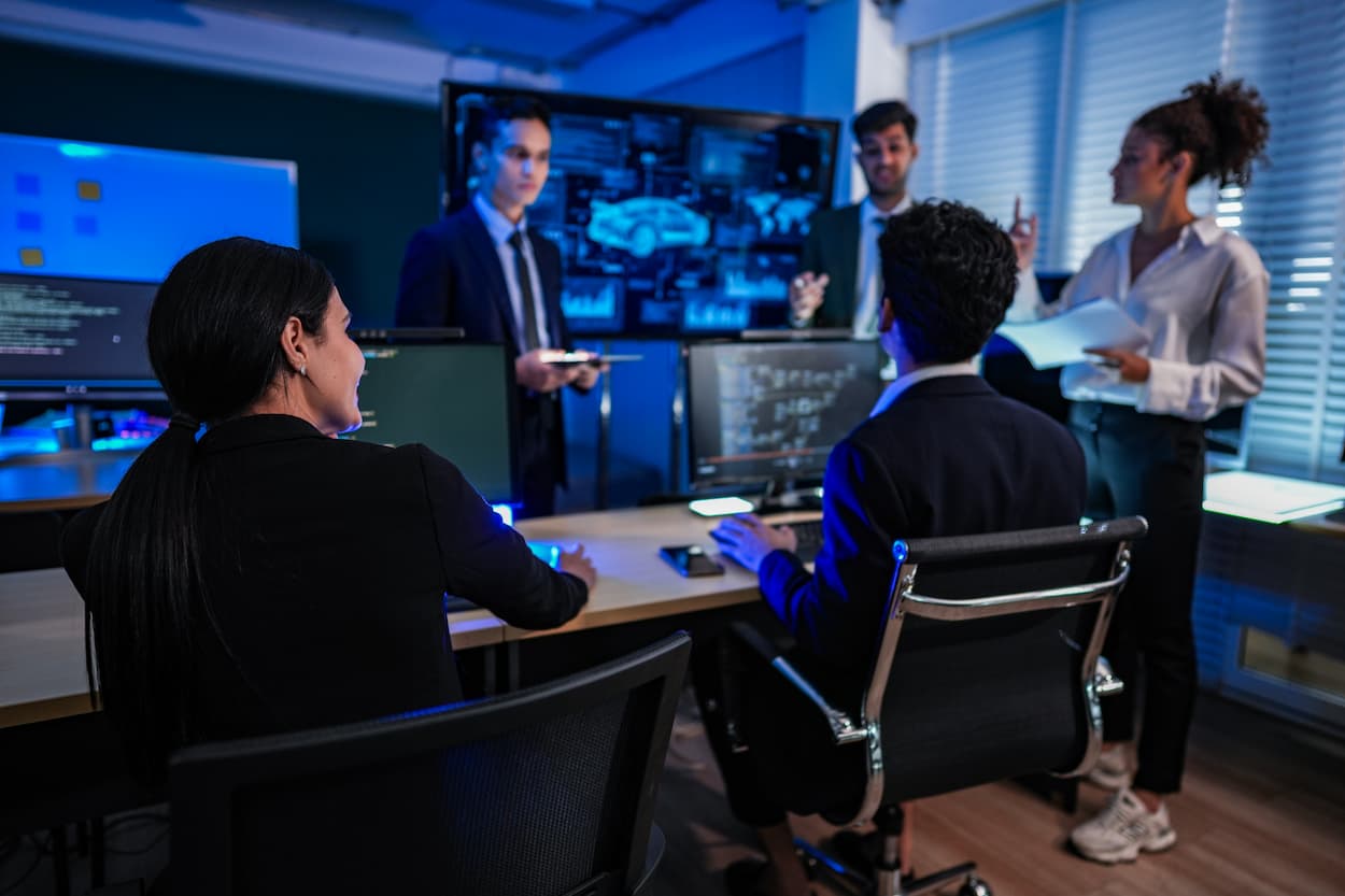Grupo de personas trabajando en una oficina, colaborando en un proyecto relacionado con la ciberseguridad y anti-DDoS.